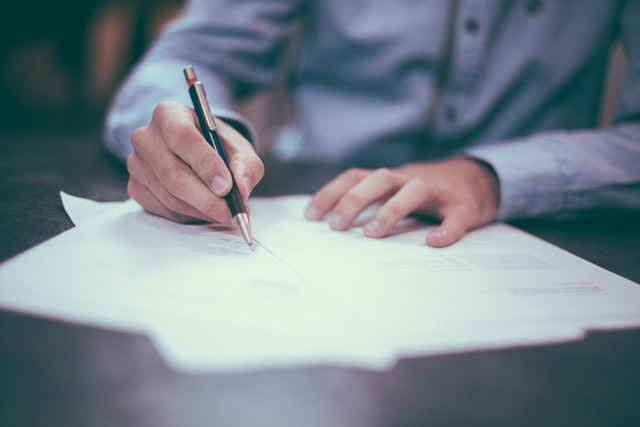Man Writing Down Business Ideas on a Notepad